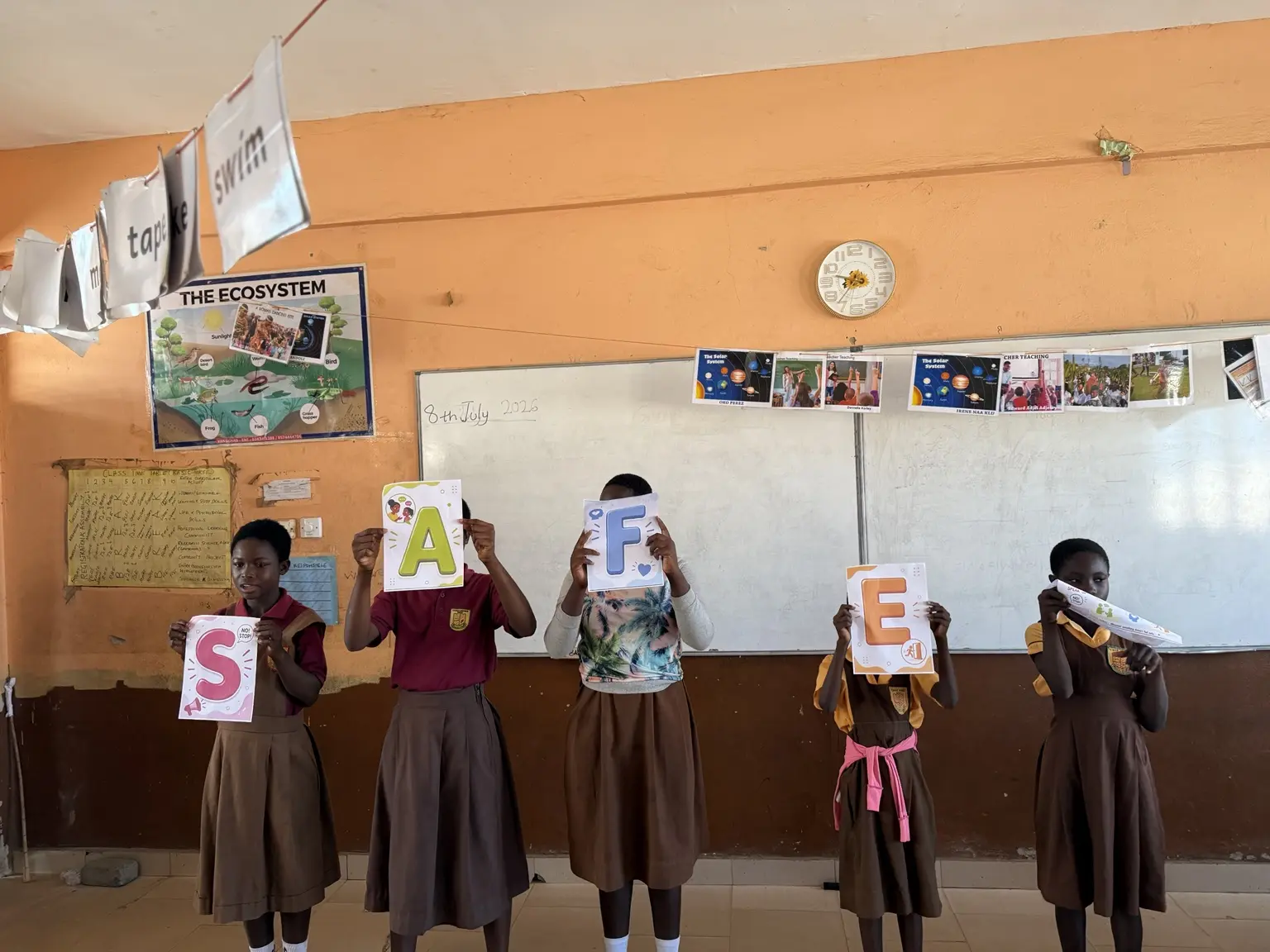 Schoolgirls presenting the word SAFE during an Ayola confidence and safety activity.